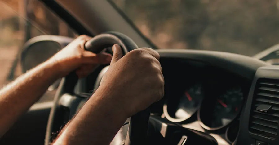 Mains d'un chauffeur sur le volant, en convoyage